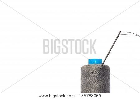 Spool of gray thread, sewing needle and thread. insulation.