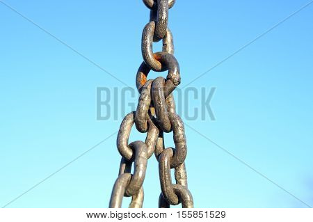 Long metal chains hanging vertically in the urban contest