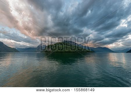 Sunset over mountains and lake. Special bright colors before storm windy