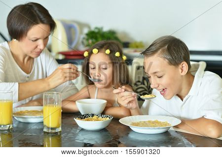 Family have breakfast. Mother feeding her little daughter