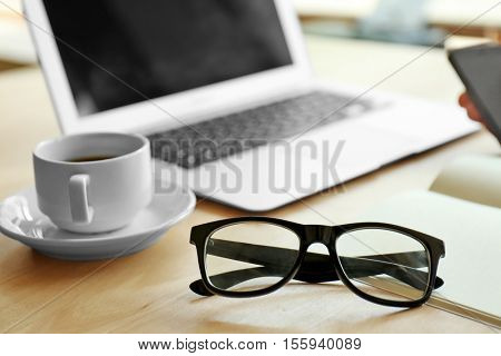 Businessman working place with laptop, glasses and cup of coffee