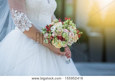 Wedding. Beautiful Weding Bouquet Of Different Flowers In The Hands Of The Bride In A White Wedding 