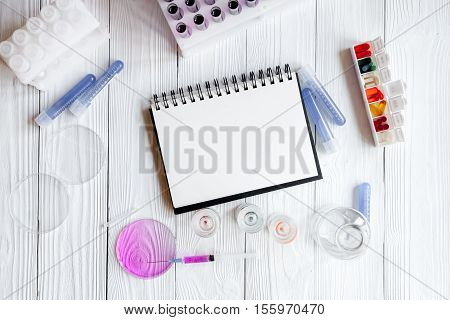 medical student working place with blank open notebook at wooden table top view