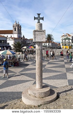 NAZARE, PORTUGAL - September 13, 2016: Limestone memory pillar with inscription and Order of Christ Cross located on the hilltop O Sitio overlooking Nazare Portugal