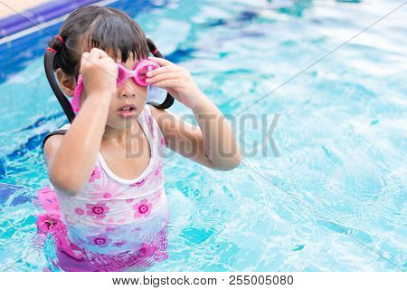 Little Asian Girl Wearing Waterproof Sunglassses Try Swimming Alone In Swimming Pool, Outdoor