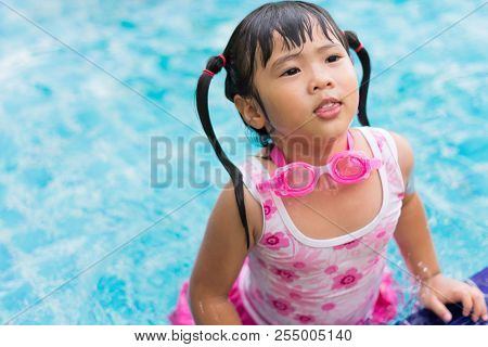 Little Asian Girl Wearing Waterproof Sunglassses Try Swimming Alone In Swimming Pool, Outdoor