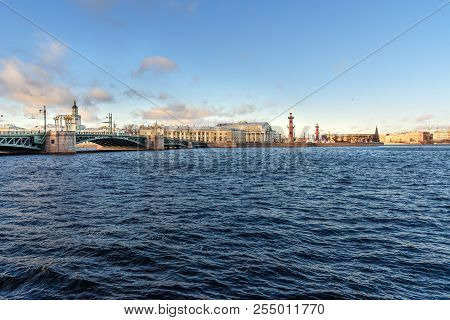 Palace Bridge And Vasilyevsky Island Spit Strelka With Rostral Columns With Fire In Saint Petersburg
