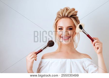 Fashion Glamour Portrait Of Happy Smiling Blonde Woman Long Wavy Hair Style Holding Brush Over Light