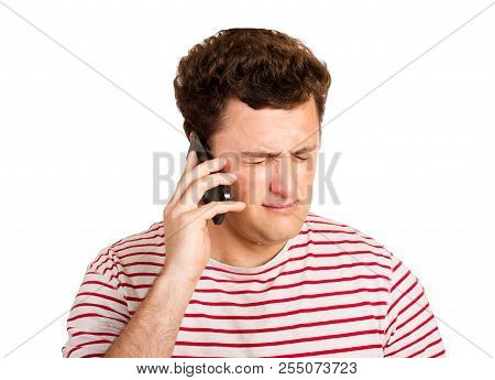 Young Man Crying Over The Bad News He Is Receiving On His Phone. Emotional Man Isolated On White Bac