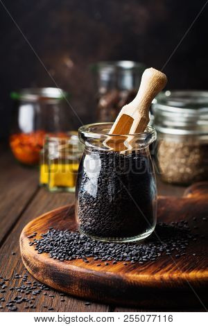 Seeds Of Black Sesame In Small Glass Jar On Dark Background. Selective Focus.