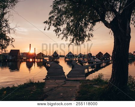 Sunset over fishing cabins at calm lake