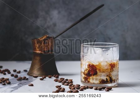 Iced Coffee Cocktail Or Frappe With Ice Cubes And Cream Served In Glass With Vintage Jezva And Coffe