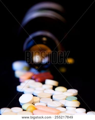 A Bottle Of Spilled Pills On Black Background.levitating Tablets. Tablets On A Dark Background That 