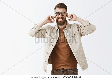 Portrait Of Intense Disspleased Mature European Guy Feeling Discomfort Covering Ears With Index Fing