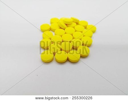 Medication And Healthcare Concept. Many Yellow Pills Of Metronidazole 200 Mg. Isolated On White Back