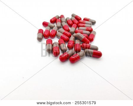 Medication And Healthcare Concept. Many Grey-red Capsules Of Flunarizine 5 Mg. Isolated On White Bac