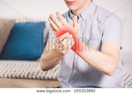 Pain In Hand, Man Suffering From Carpal Tunnel Syndrome At Home, Painful Area Highlighted In Red