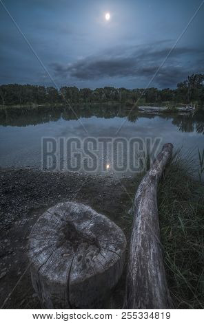 Night Landscape With The Tree Stump By The Lake Lit By The Shining Moon