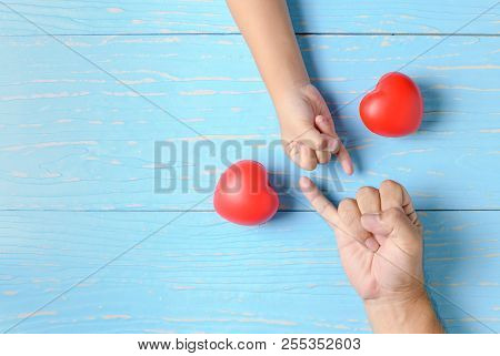 Father And Kid Hand To Pinky Swear, Pinky Promise Hand Signs On Blue Wood Background And Copy Space