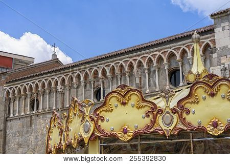 Gallarate, Varese, Lombardy, Italy: Exterior Of The Medieval San Pietro Church And A Carousel