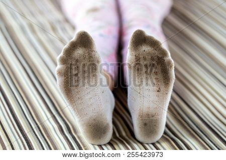 Pair Of Child Feet In Dirty Stained White Socks. Kid Soiled Socks While Playing Outdoors. Children C