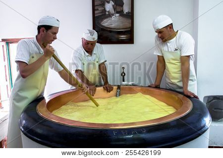 Primiero San Martino Di Castrozza - Italy - July 31, 2018 - A Team Of Cheesemakers At Work In A Dair