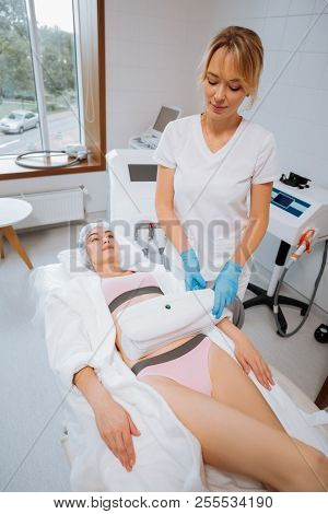 Delighted Nice Cosmetologist Doing A Velashape Procedure