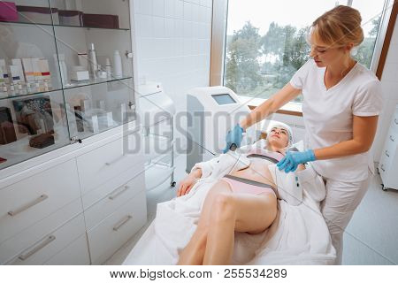 Professional Female Cosmetologist Using A Velashape Device