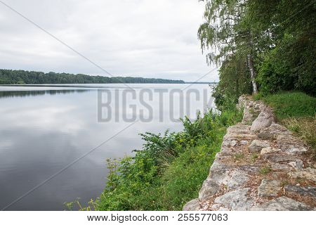 Latvia. Old River And Green Trees. Ruins And Reflection.