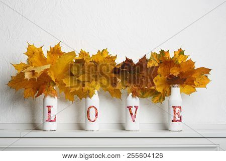 Autumn Maple Leaves In Bottles With Written Word Love On White Background. Autumn, Fall, Love To Nat