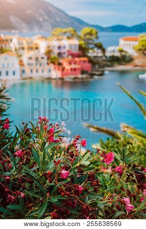 Beautiful View Of Assos Village With Vivid Colorful Houses Near Blue Turquoise Colored And Transpare