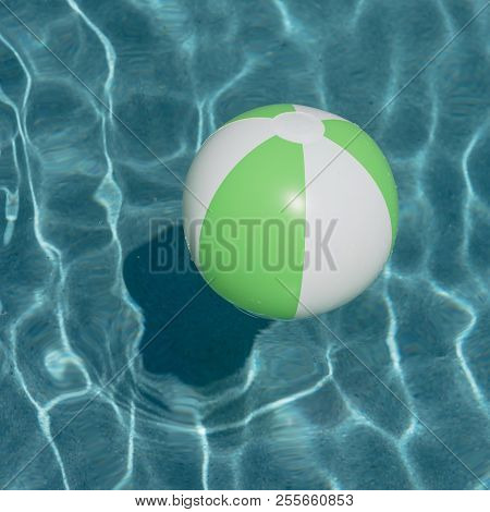 Close-up One Bright Green Beach Ball In Swimming Pool Sunny Day
