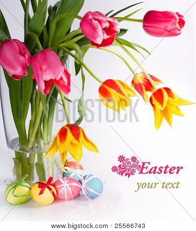 Ovos de Páscoa bonitos com curvas e as tulipas no fundo branco
