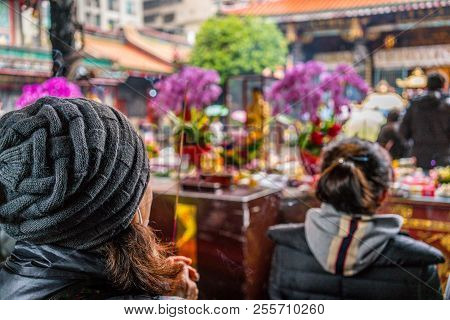 Unrecognizable Asian Woman Holding An Incense Stick Praying At Lungshan Buddhist Temple Of Manka In 