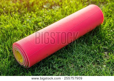 Yoga Mat On The Grass In Summer Park. Sport Equipment