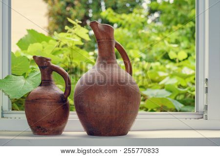 Wine Jugs On The Window Sill, Grape Leaves Background