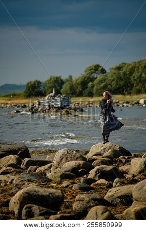 The Girl Is Standing In A Dress On The Shore Of The White Sea