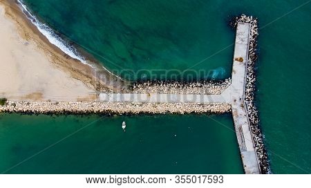 Concrete Tetrapod Wave Breaker With A Boat Anchored By The Side