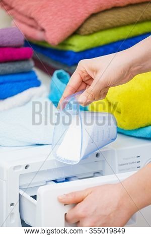 Washing Powder Detergent And Measuring Cup Pouring Into Machine. Household Duties, Clothes Laundry O