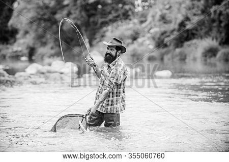 Bearded Fisher In Water. Young Man Fishing. Successful Fly Fishing. Fisher Masculine Hobby. Man With