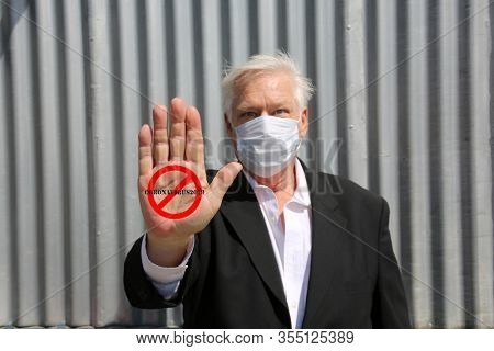 Coronavirus outbreak. COVID-19. A man wears a Paper Face Mask with a NO Symbol and Coronavirus2019 text. Influenza dangerous flu strain cases as a pandemic medical health risk. 2019-nCoV. Wuhan China.