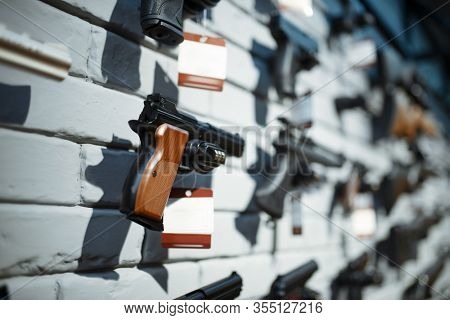 Handguns on showcase in gun shop closeup, nobody