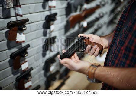 Man holds handgun in gun shop