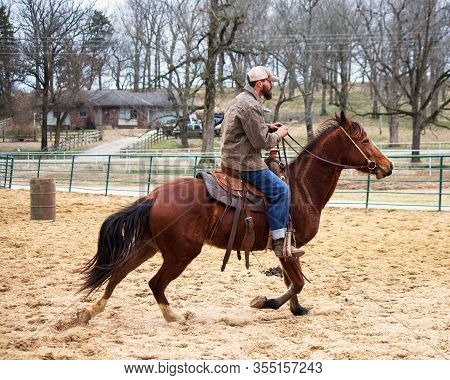 Male Rider/trainer Working A Horse In The Arena