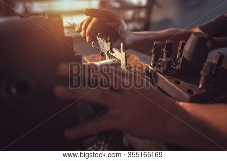 Close-up Worker Handles Metal At Lathe Turner Measures The Dimensions Of The Metal Workpiece With A 