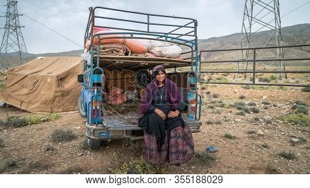 Shiraz, Iran - May 2019: Qashqai Woman Sitting By An Old Car. The Qasqhai Are Nomadic People Living 