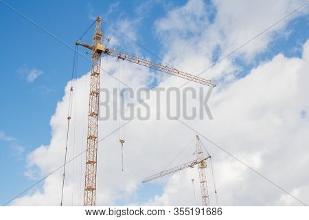 Two Construction Cranes Against The Sky. Construction With A Crane