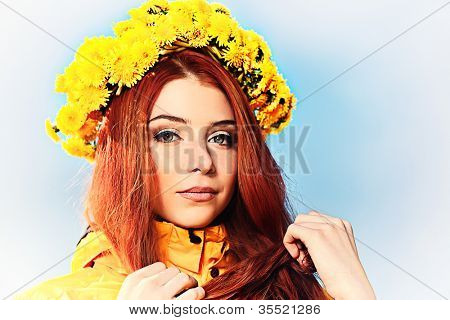 Portræt af en romantisk ung kvinde i en tudorroser af blomster udendørs.