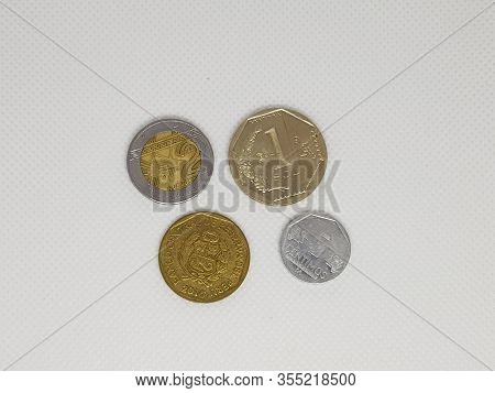 Some Peruvian Coins In A White Background Pesos