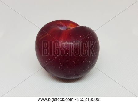 Picture Of A Red Plum On A White Background
